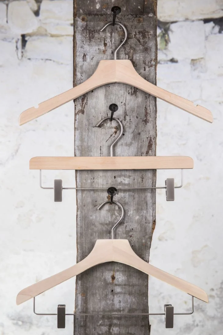 Set aus drei Naturholz-Kleiderbügeln – ideal für Boutique oder Hotelausstattung.