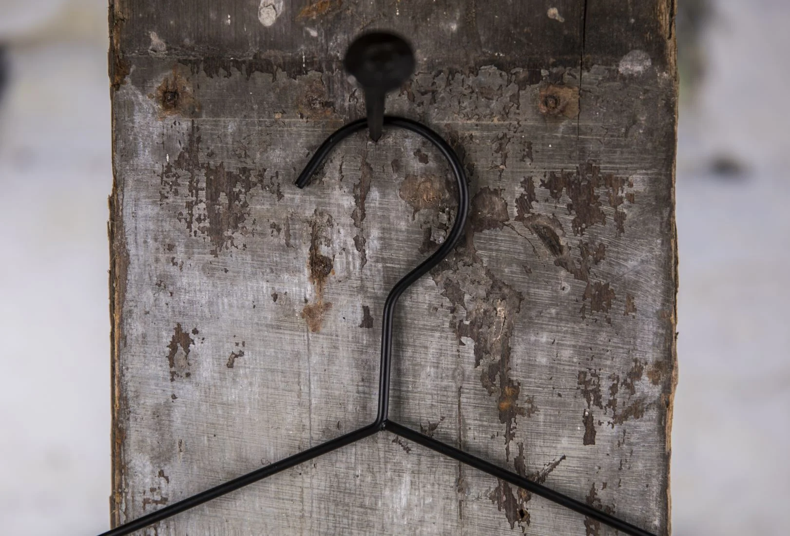 Simple black metal wire hanger with hook suspended on wooden board - Minimalist solution for everyday and professional presentation of shirts in store, warehouse and showroom (shirt hanger)