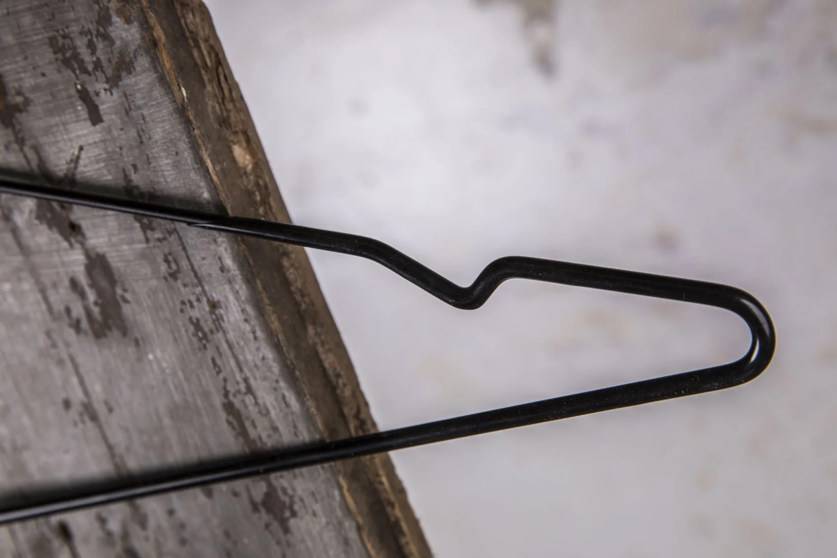 Schwarzer Metallbügel mit breiten, schrägen Schultern – Stabiler Bügel für Jacken oder Mantel.