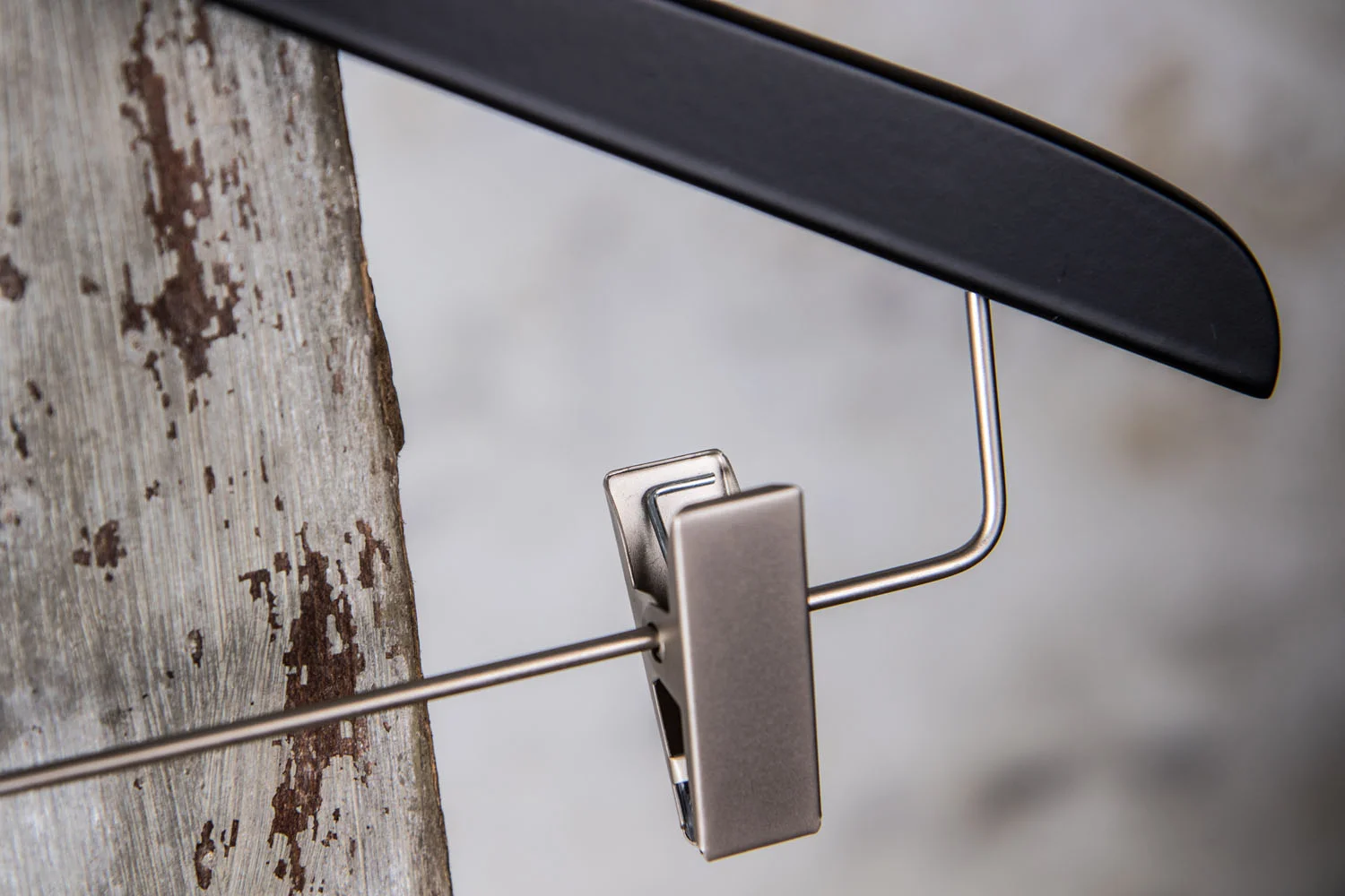 Detailaufnahme eines Metallclips an einem schwarzen Holzbügel - rutschfest und stabil für Businesskleidung.