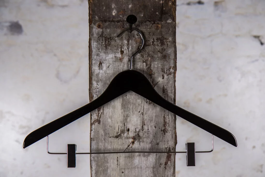 Schwarzer Bügel mit silbernen Clips – Professionelle Präsentation von Röcken oder Hosen.