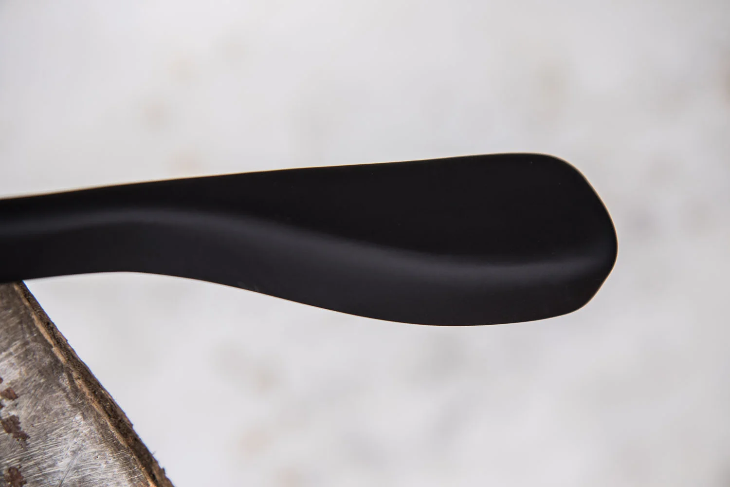 Detailaufnahme eines schwarzen Hochglanzbügels mit sanft geschwungener Schulter – Premium-Finish für hochwertige Präsentation.