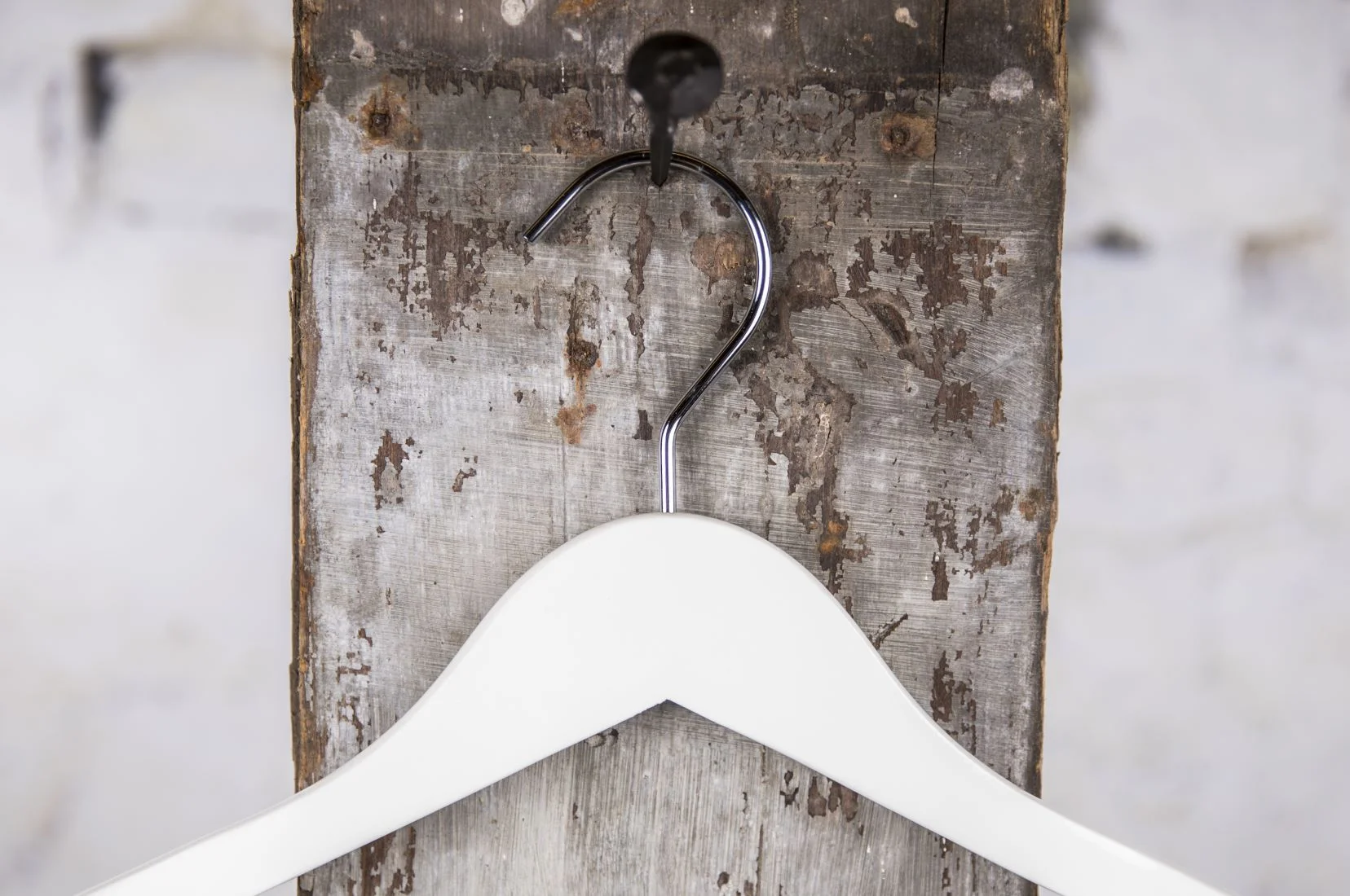 White hanger with softly rounded shape suspended - Simple and well-made solution for professional presentation in store and showroom (hanger)