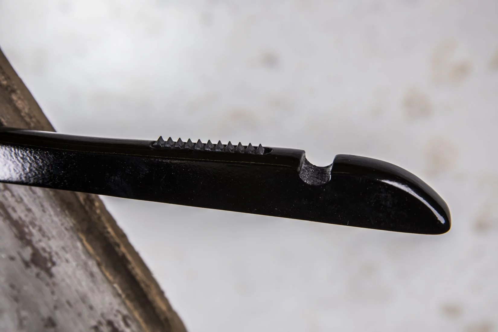 Detail eines schwarzen Hochglanzbügels mit Zähnen für Träger – Sicherer Halt für feine Stoffe.