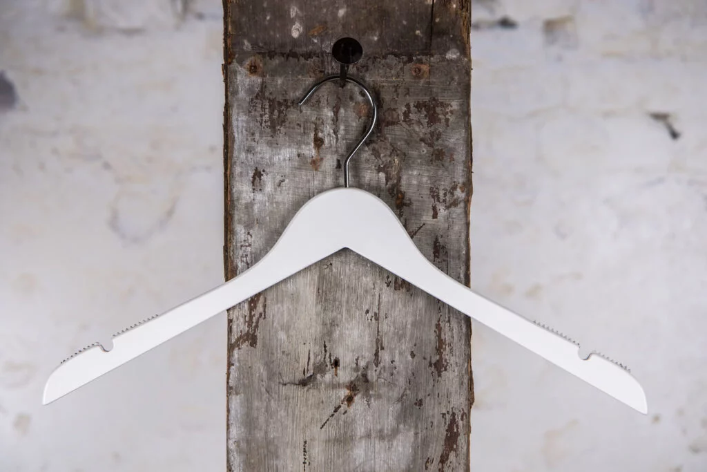 Weißer Kleiderbügel mit modernem Touch – diskreter Kleiderbügel für die Boutique-Präsentation.
