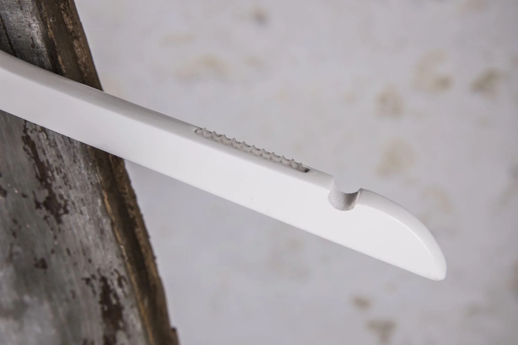 Detailaufnahme eines weißen Bügels mit Metallzähnen für rutschfesten Halt – Funktionales Detail für empfliche Textilien.