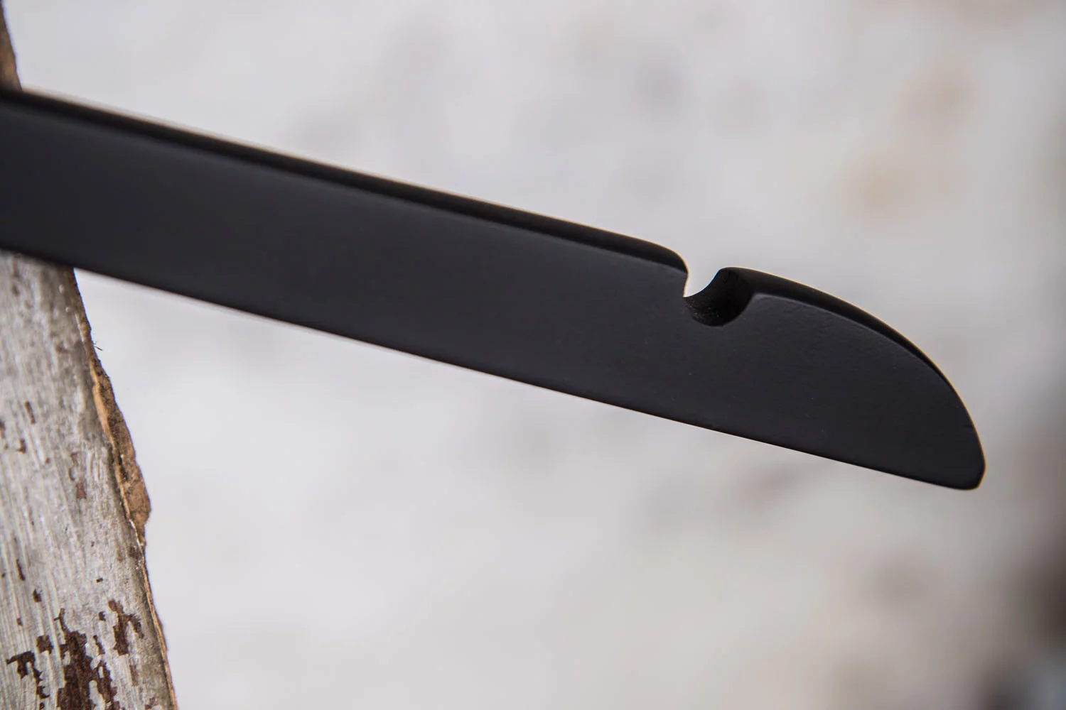 Detail eines schwarzen Hochglanz-Kleiderbügels mit Einkerbung zur Unterstützung - sicherer Halt für feine Stoffe.