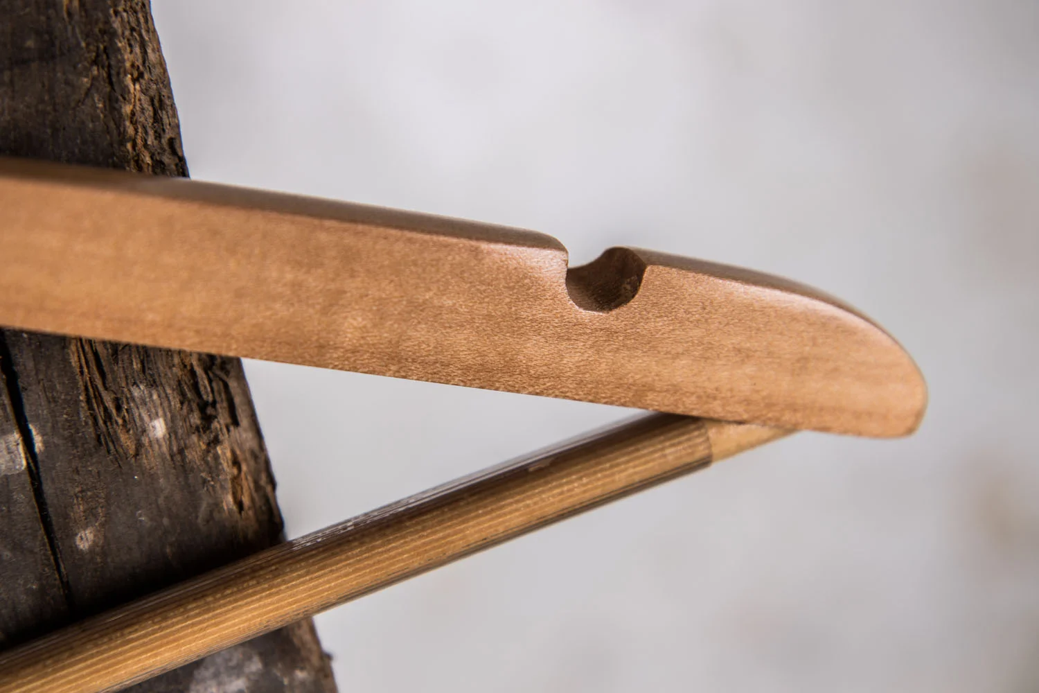 Detail eines rustikalen Holzbügels mit Einkerbung für Träger und Hosensteg – Authentischer Vintage-Look mit Funktion.