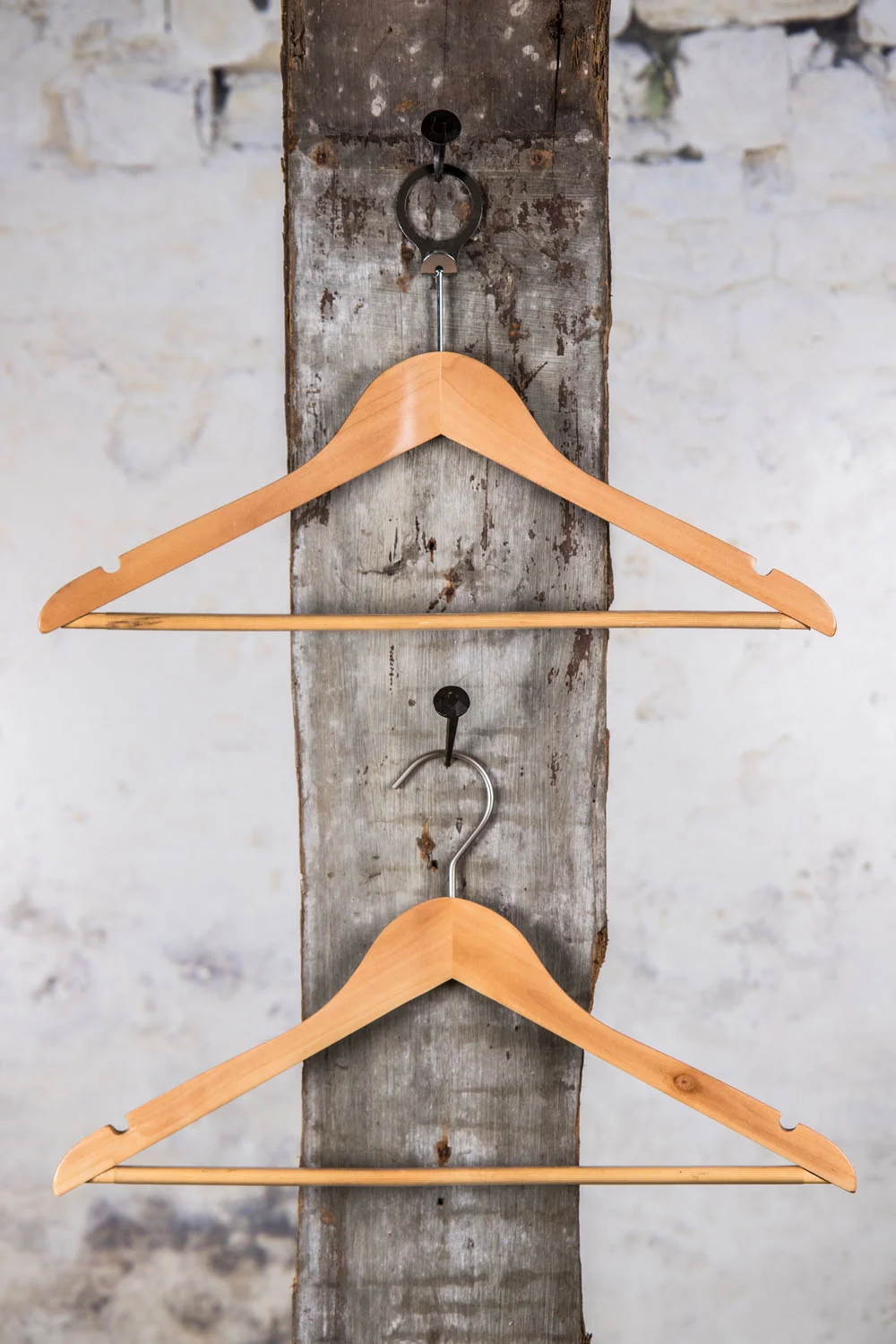 Zwei naturfarbene Holzkonsolen, vertikal an einer Wandhalterung aufgehängt – warme Holzoptik für eine klassische Präsentation.