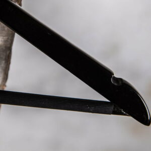 Detail eines schwarzen Hochglanzbügels mit Einkerbung für Träger – Sicherer Halt für feine Kleidung.