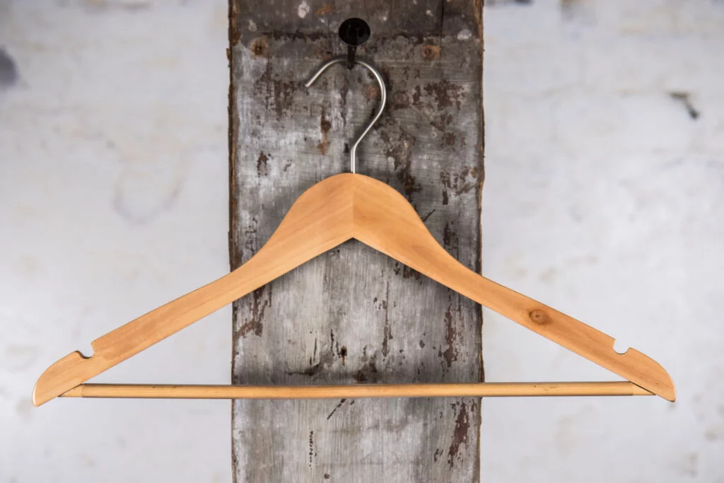 Kleiderbügel aus Naturholz mit geschwungenen Schultern – warmer Holzton für stilvolle Kleidung.