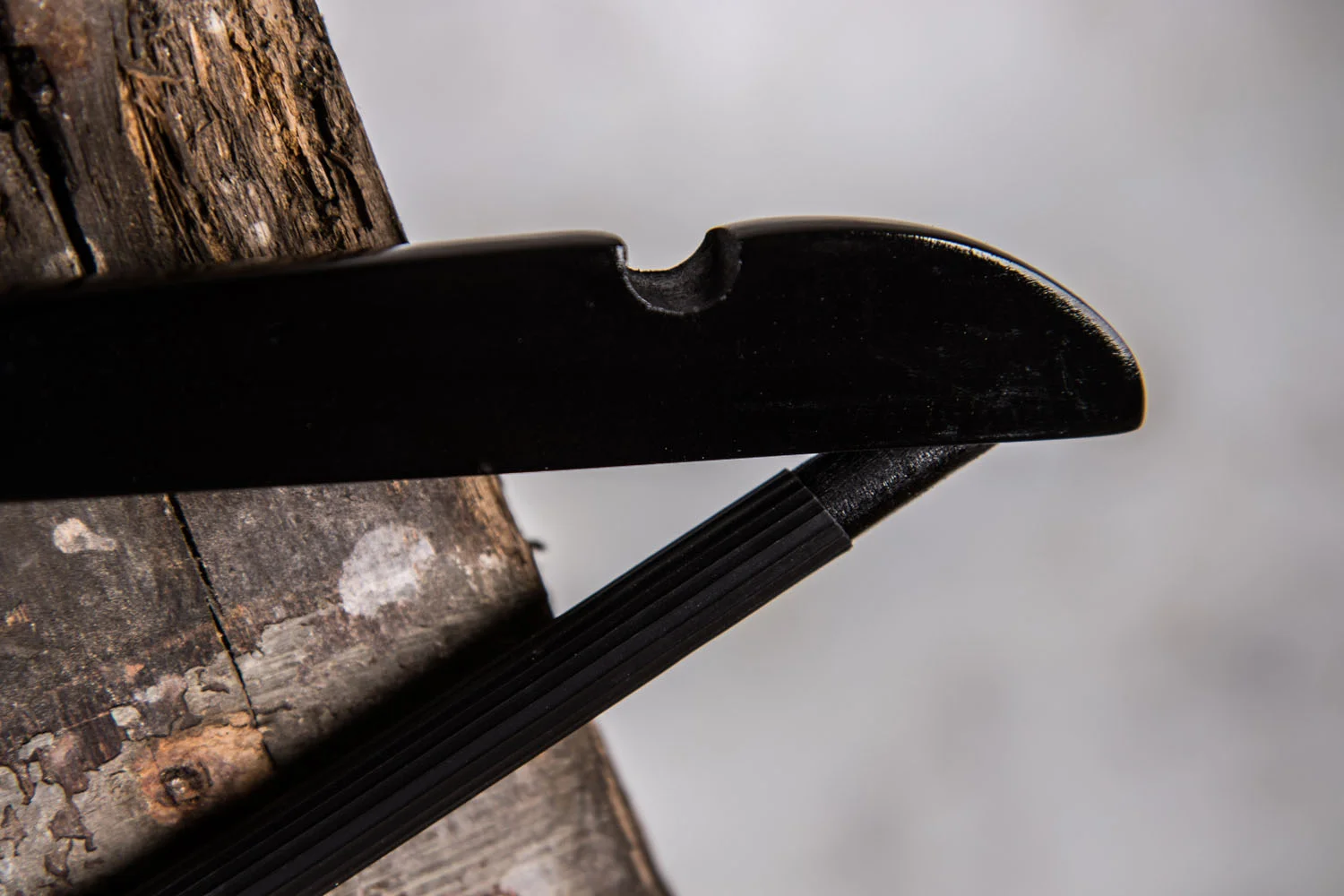 Detailaufnahme eines schwarzen Hochglanzbügels mit Einkerbung für Träger – Funktionales Design element für rutschfesten Halt.