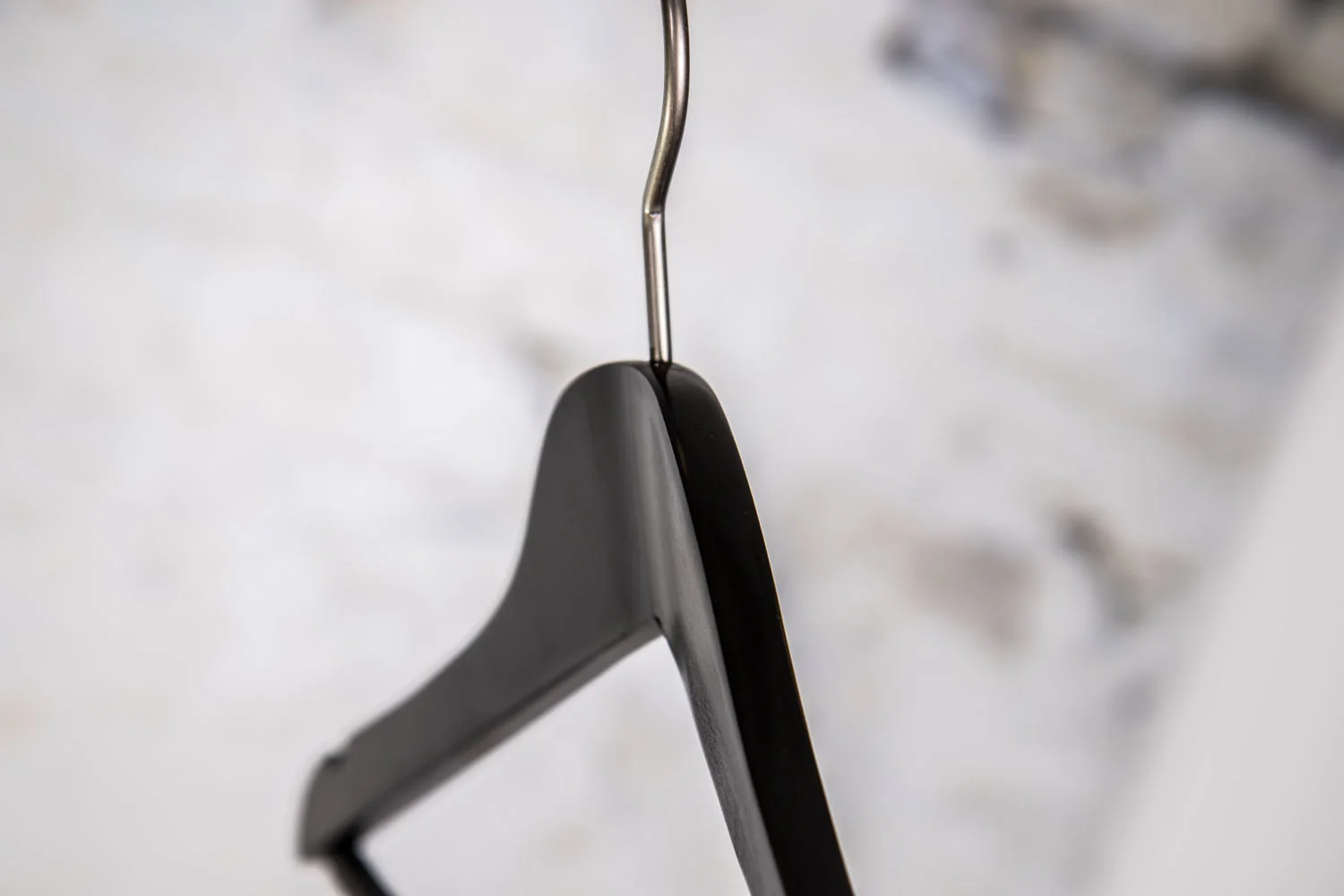 Schwarzer Anzugsbügel mit Haken, seitlich photographed – Robust Design for heavy clothing.