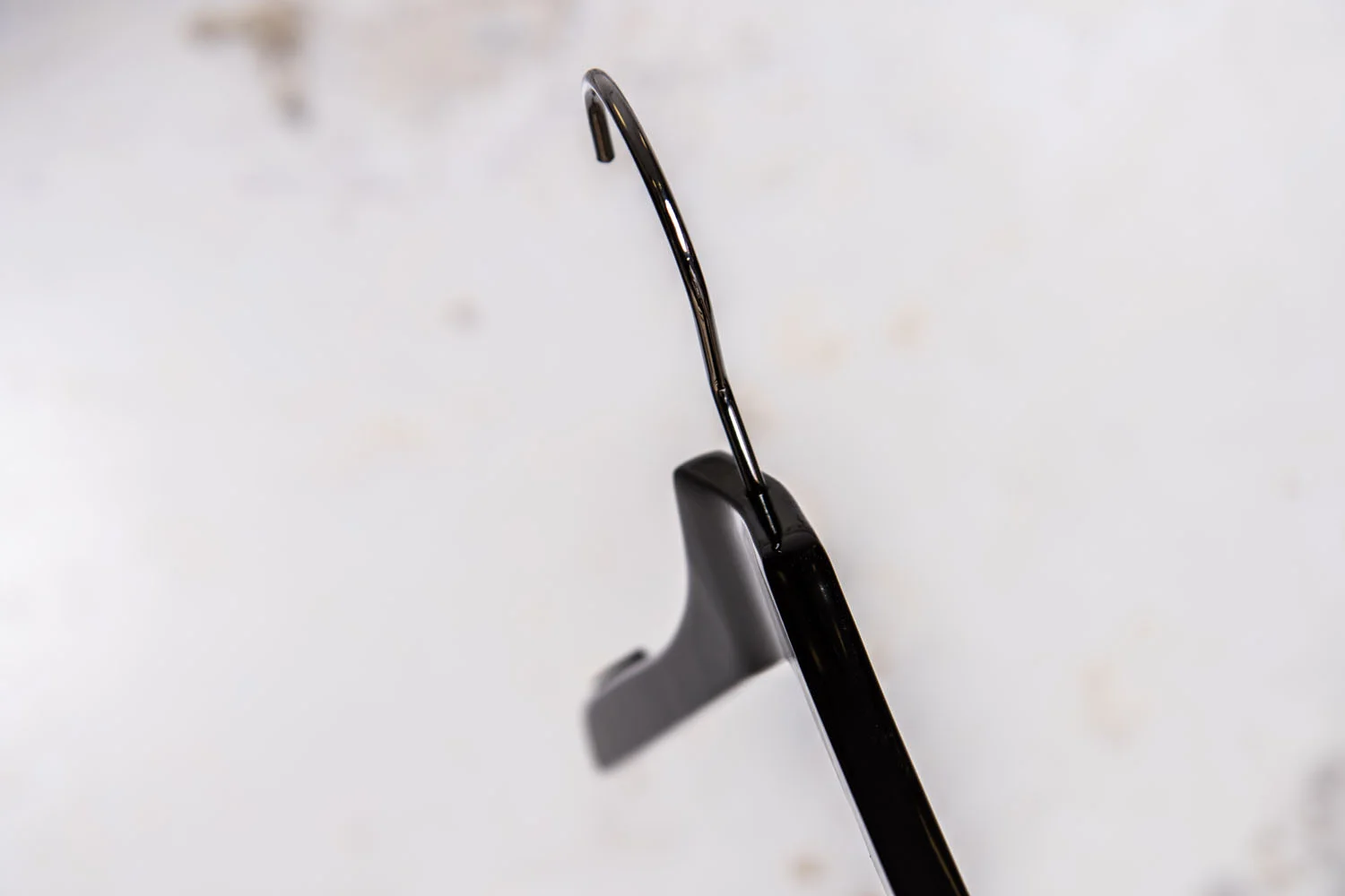 Nahaufnahme eines schwarzen Kunststoffbügels mit Metallhaken – Robustes Modell für den täglichen Einsatz.