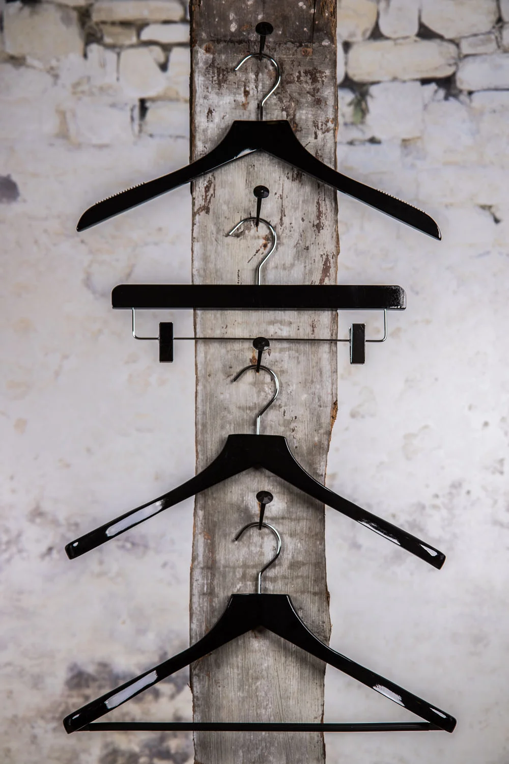 Drei schwarze Halterungen mit einer zentralen Cliphalterung, vertikal aufgehängt – Elegante Lösung für eine komplette Präsentation.