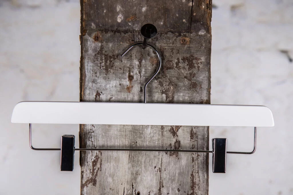 White trouser hanger with black metal rod and clips - Contrasting design for modern decor as a clip hanger.