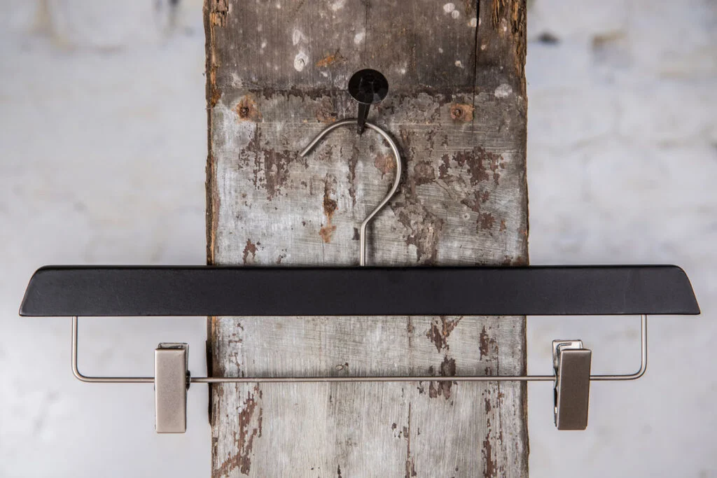 Sort buksebøjle med mørk metalstang og robuste clips – Tidløst design til klemmebøjle til professionel brug.