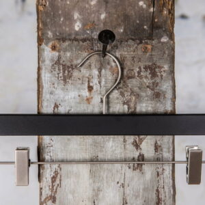 Schwarzer Hosenbügel mit dunkler Metallstange und robusten Clips – Zeitloses Design für professionelle Verwendung.