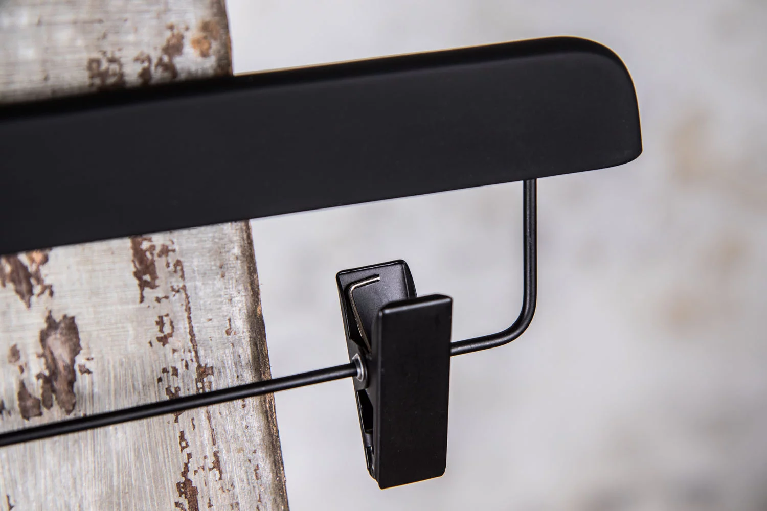 Detailansicht eines schwarzen Hosenbügels mit schwarzem Clip – schlichtes, praktisches Design.