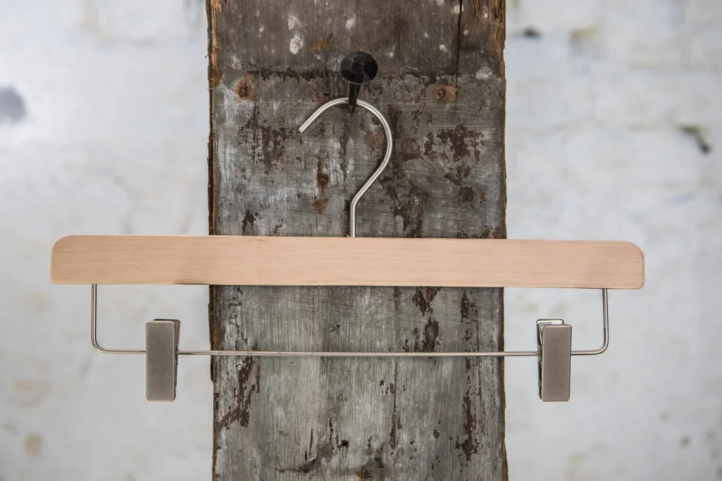 Enkel træbuksebøjle i naturfarve med sølv metalstang og clips – Minimalistisk design til klemmebøjle.