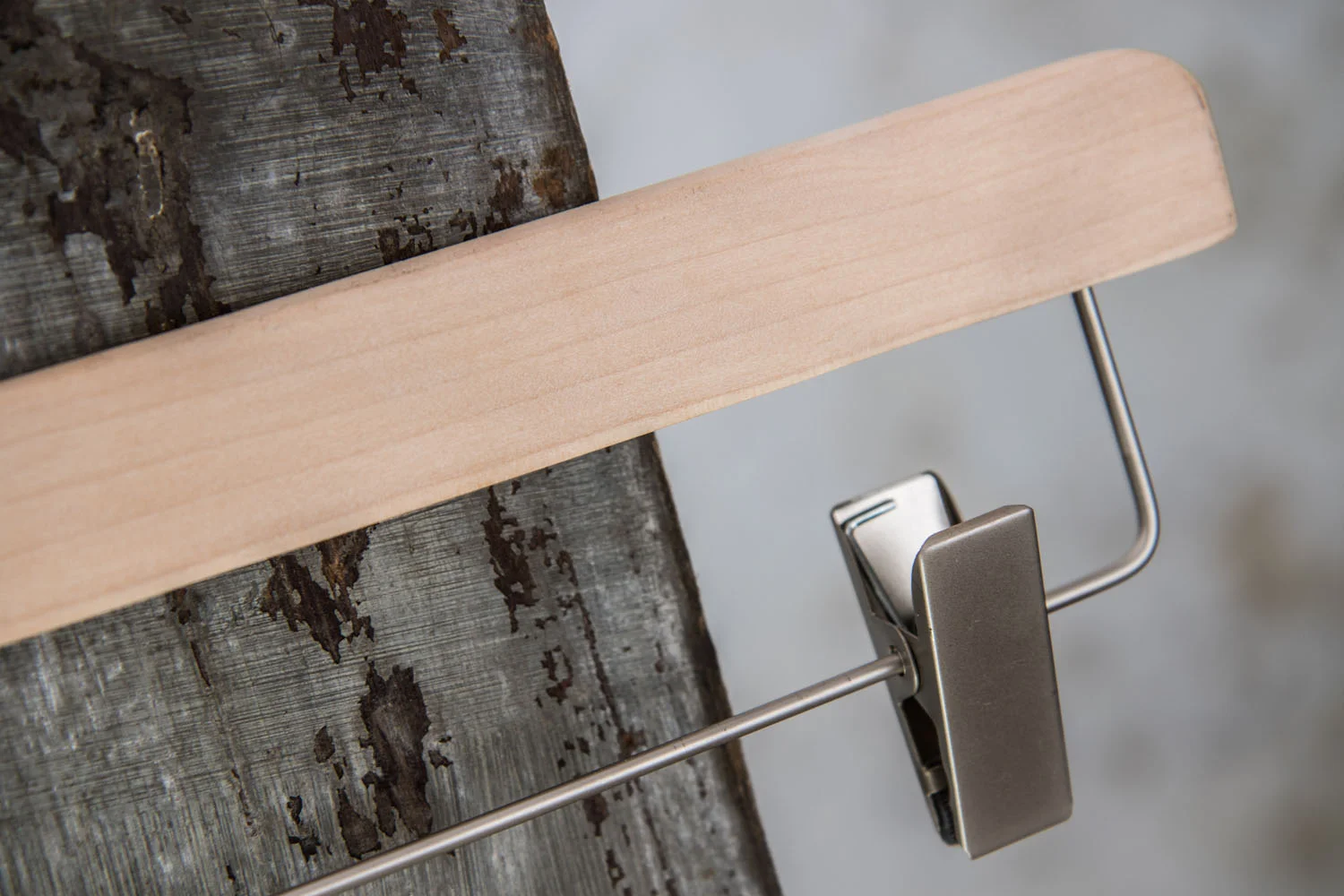 Nahaufnahme eines naturfarbenen Hosenbügels mit silbernem Clip und Metalstalgen – Focus auf high-quality materials and clasp mechanics.