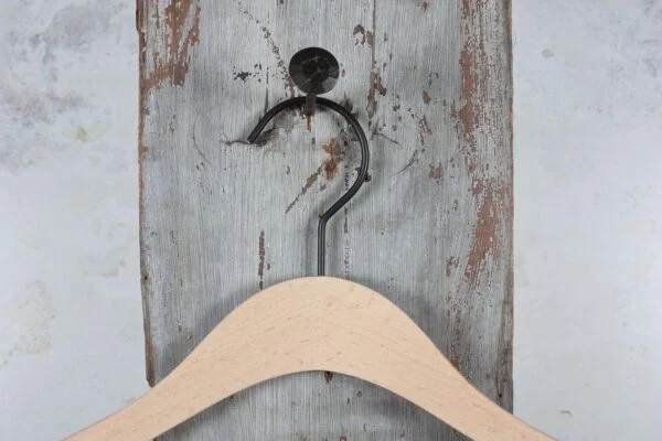 Nahaufnahme eines Holzkleiderbügels mit Metallhaken – Kombination aus natürlichem Material und robustem Haken.