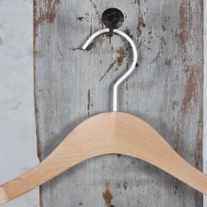 Holzbügel mit markanter Schulterform und silbernem Haken – Für schwere Kleidungsstücke geeignet.