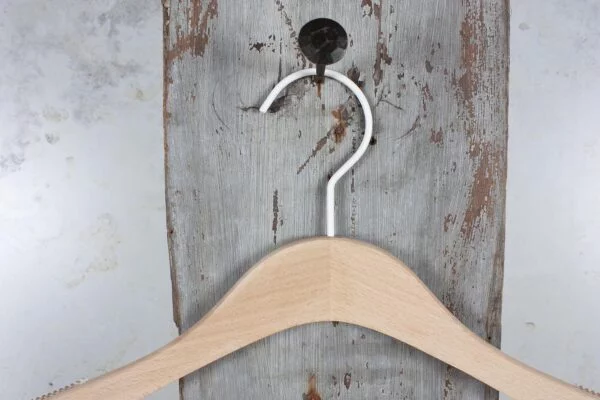Naturholz-Kleiderbügel mit silbernem Haken, frontal aufgehängt – Schlichtes, professionelles Design.