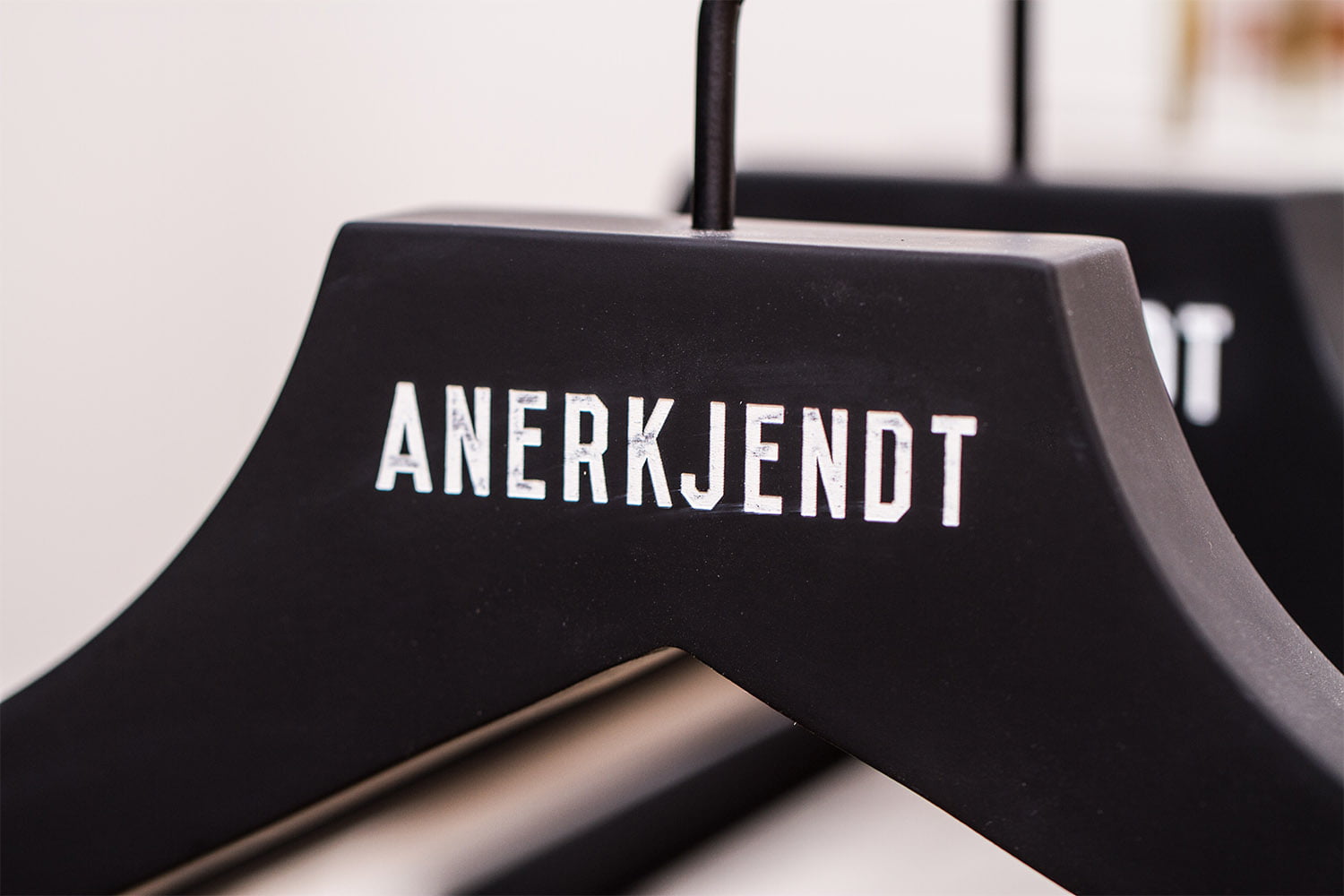 Schwarzer Kleiderbügel mit dem Logo "RECOGNIZED", klassisch und stilvoll für die moderne Garderobe.