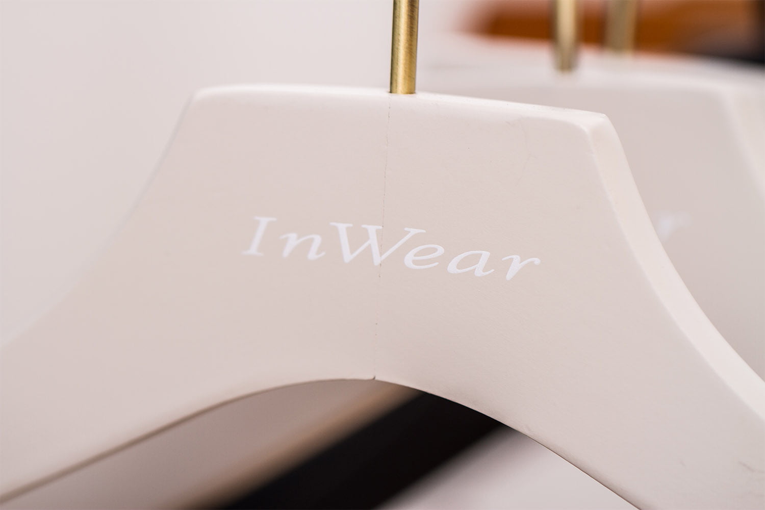 Weißer Kleiderbügel mit "InWear"-Logo, stilvoll und funktional für Bekleidungsgeschäfte und Showrooms.