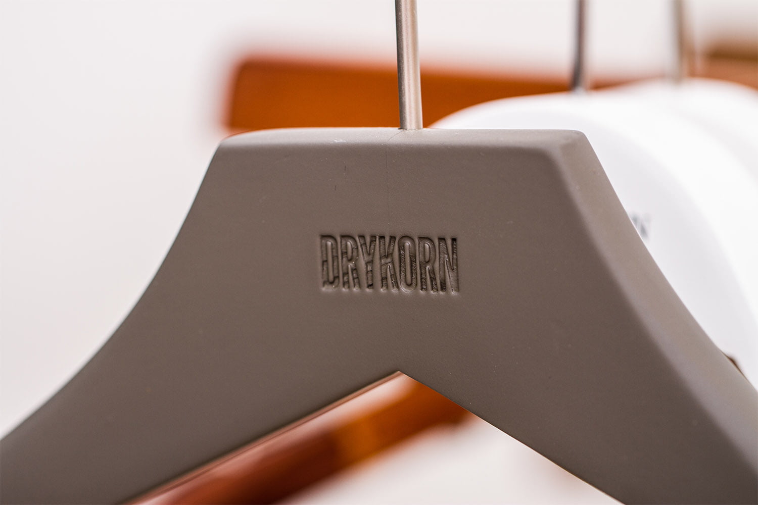 Weißer Kleiderbügel mit stilvollem "Drykornn"-Logo für einen eleganten Look.