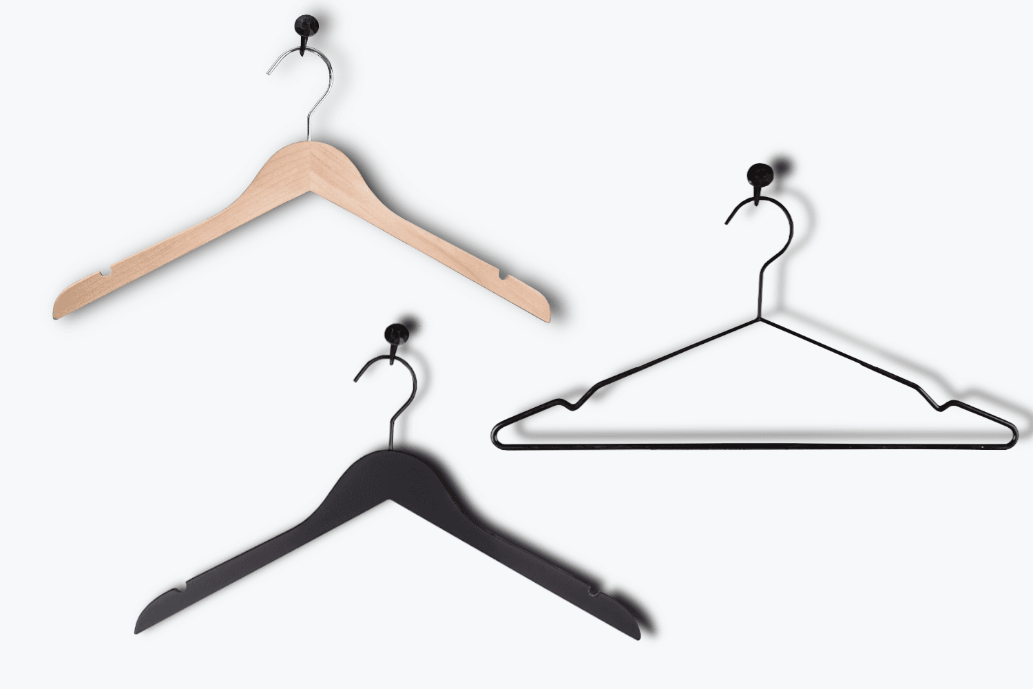 A stylish retail environment with three types of hangers on clothing racks: classic wooden hangers with logo, wooden hangers with rubber coating for silk blouses, and slim metal hangers for minimalist presentation – all highlight the clothes and support the store's visual identity. Choose the perfect hanger for your store – wooden hangers, rubber coated hangers and metal hangers from Hang On