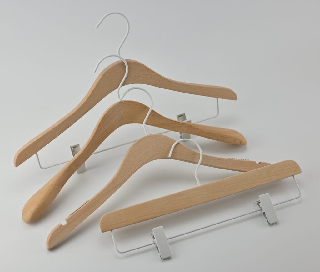 Træbøjler i naturfarve med hvidt metalophæng og bukseklemmer