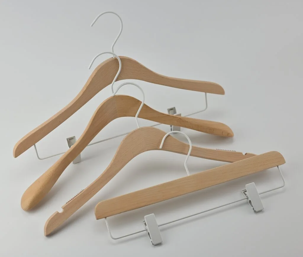 Kleiderbügel aus Naturholz mit weißen Metallbügeln und Hosenclips
