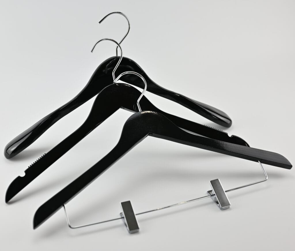 Sorte træbøjler med krom metalophæng og bukseklemmer