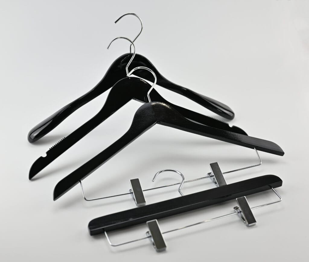 Sorte træbøjler med blank finish, kromkroge og buksebøjler med klemmer