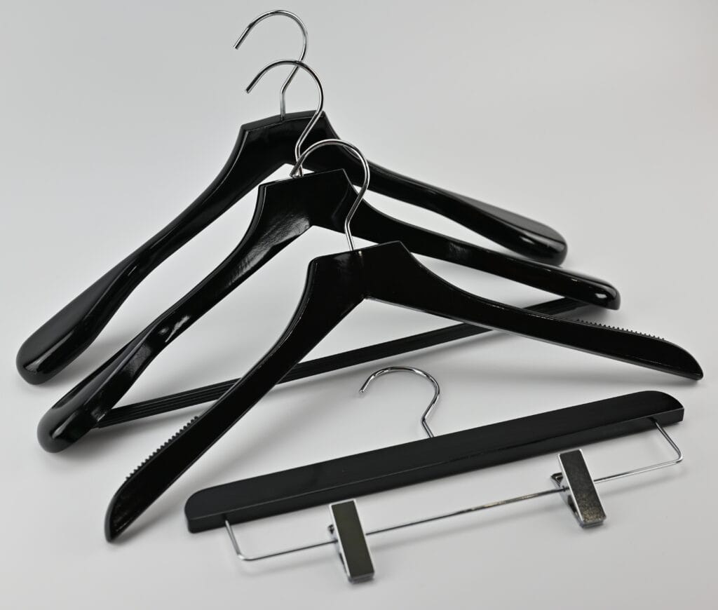 Sorte træbøjler med blank overflade, kromkroge og buksebøjle med klemmer